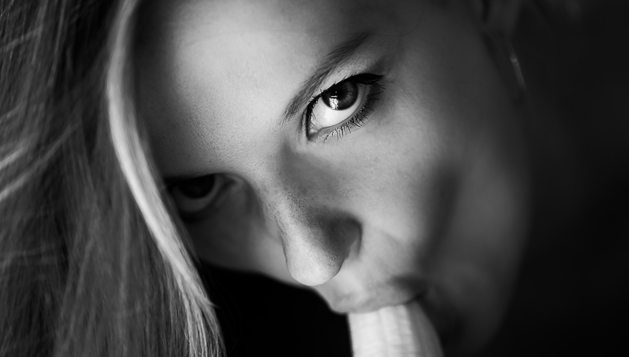 Blowjob - junge Frau saugt und leckt eine Banane