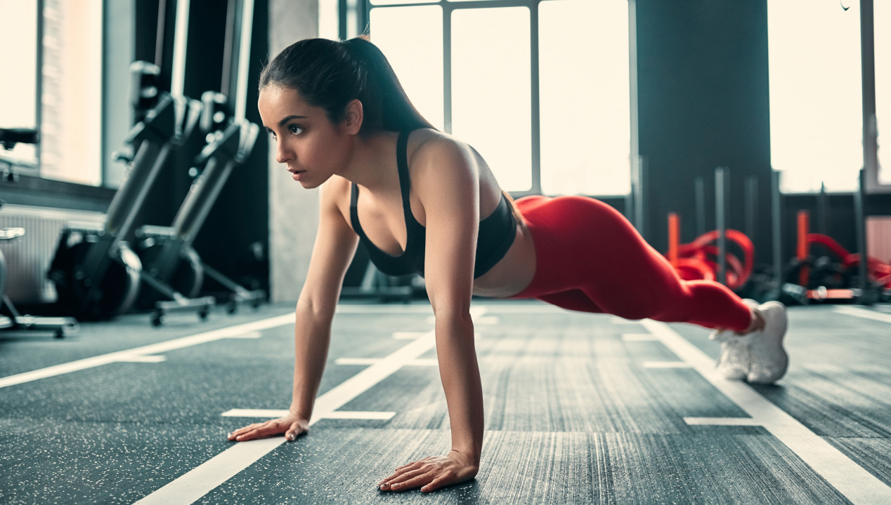 Junge Frau, die im Gym Planks ausführt