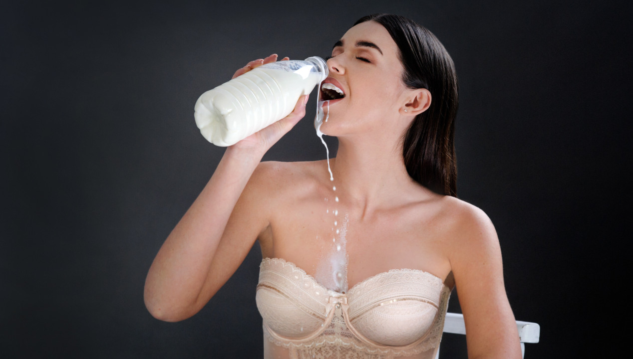 Cum Eating Instructions (CEI) Fake - junge Frau in Corsage trinkt aus einer Flasche Milch